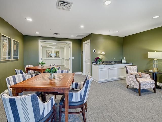 dining room with light colored carpet, visible vents, baseboards, and recessed lighting