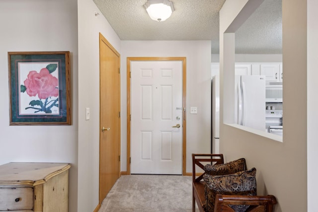 entryway featuring light colored carpet and a textured ceiling