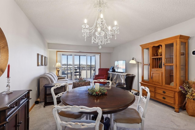 dining area with a chandelier, light carpet, and a textured ceiling