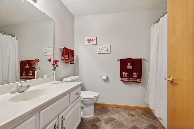 bathroom with vanity, a textured ceiling, and toilet