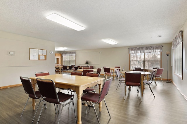 dining room with dark wood-type flooring and a textured ceiling