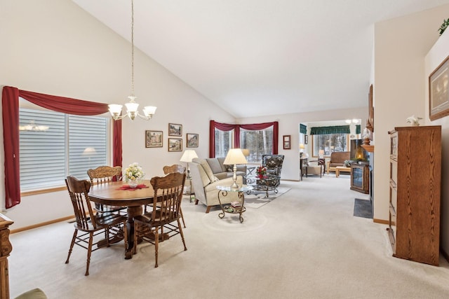 dining area with baseboards, light colored carpet, high vaulted ceiling, and an inviting chandelier