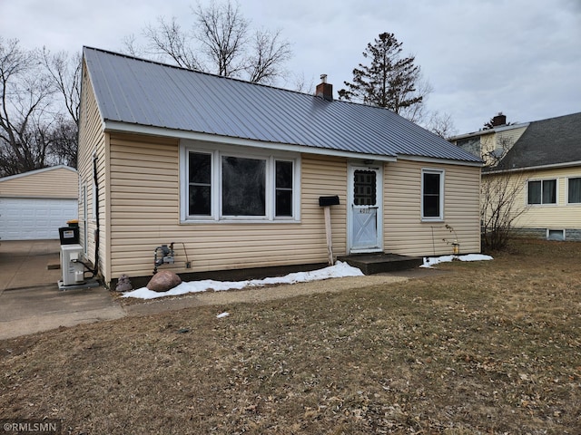 view of front facade featuring a front lawn, a garage, and an outbuilding