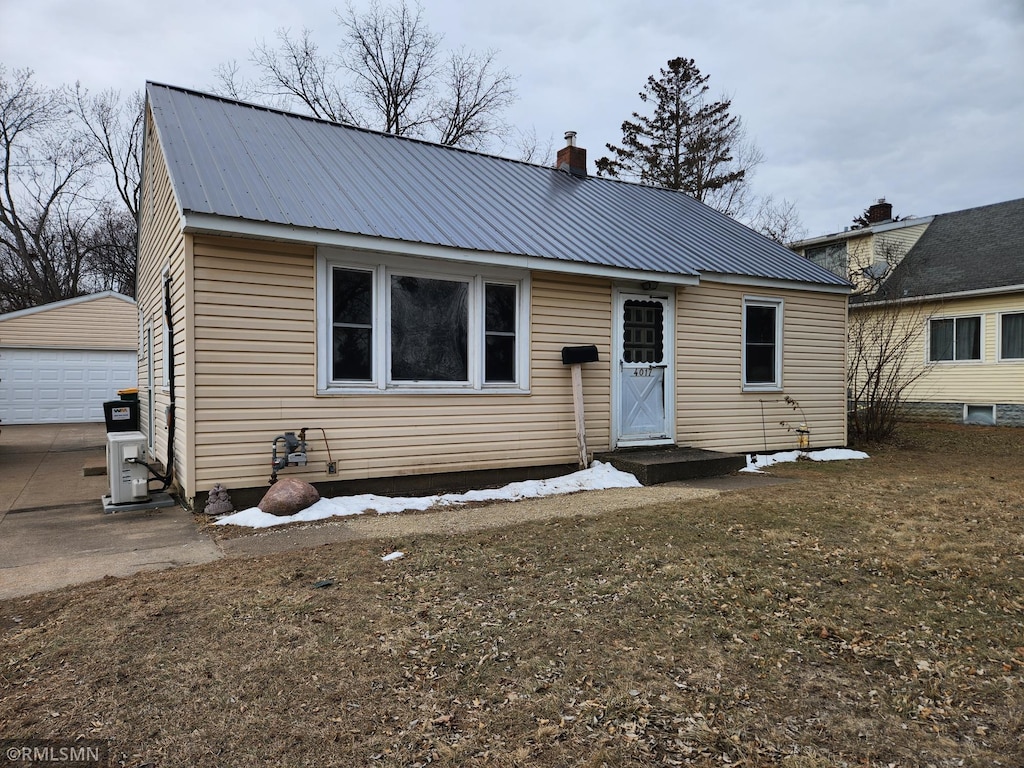 view of front facade with a front lawn, an outdoor structure, and a garage