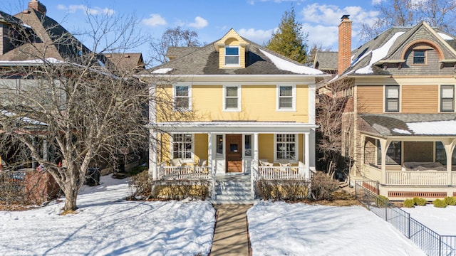 traditional style home featuring covered porch and fence