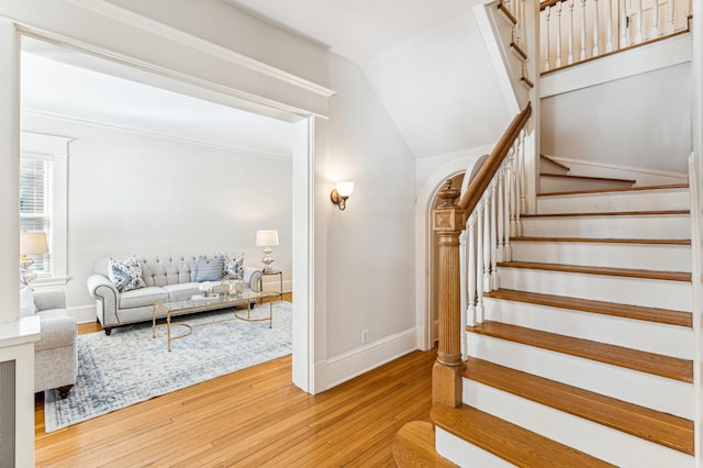 staircase featuring vaulted ceiling, baseboards, and wood-type flooring