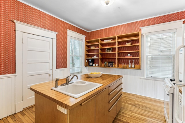 kitchen featuring wallpapered walls, white gas stove, wooden counters, and a sink