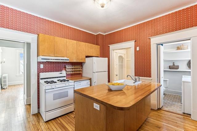 kitchen with wallpapered walls, under cabinet range hood, butcher block counters, white appliances, and a sink