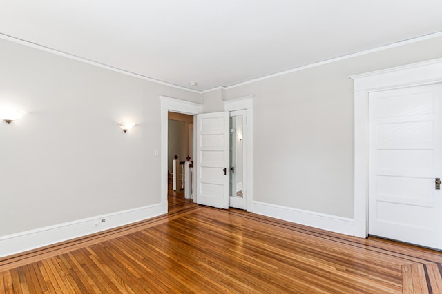 unfurnished bedroom with baseboards, wood-type flooring, and crown molding