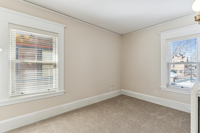 carpeted empty room featuring baseboards