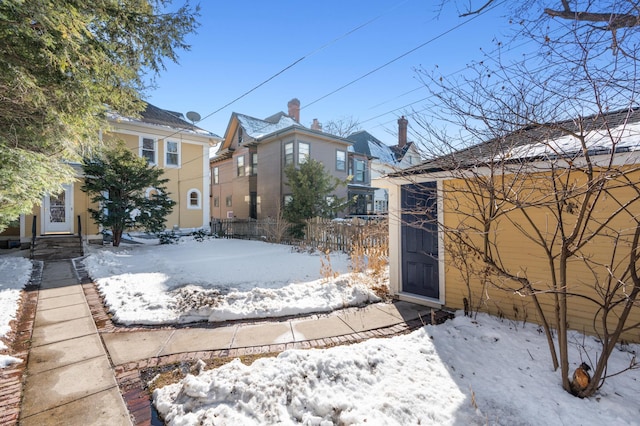 yard covered in snow with entry steps and fence