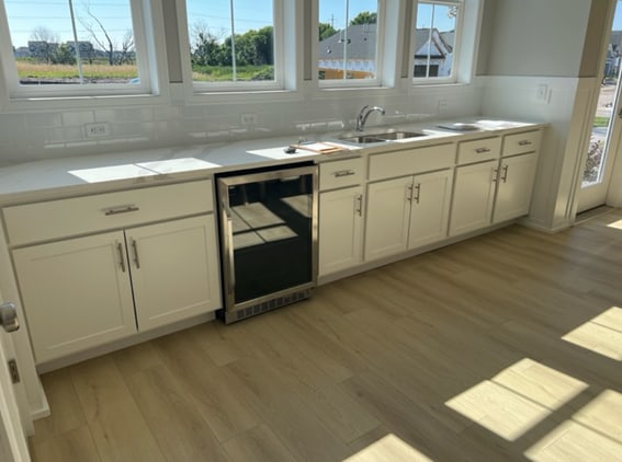 kitchen with light hardwood / wood-style floors, decorative backsplash, beverage cooler, white cabinets, and sink