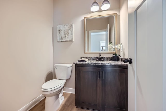 bathroom with toilet, wood-type flooring, and vanity