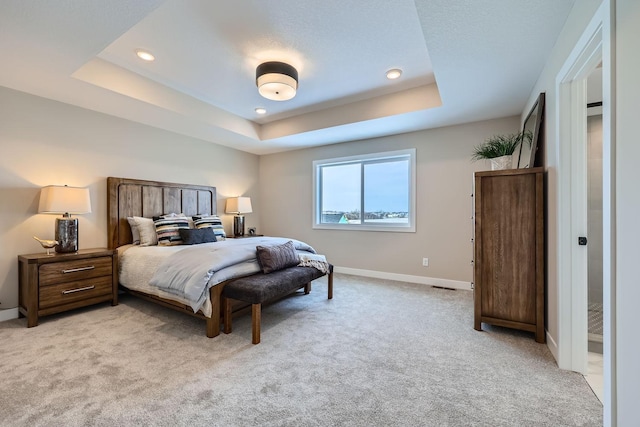 carpeted bedroom featuring a tray ceiling