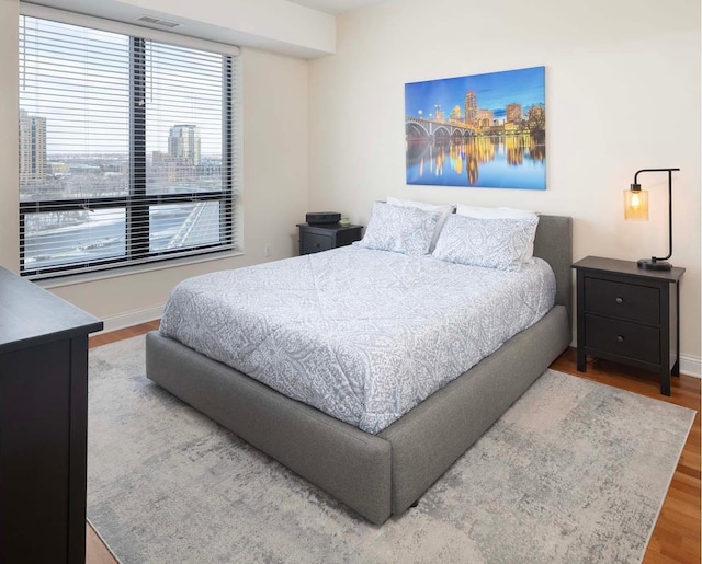 bedroom with multiple windows and wood-type flooring