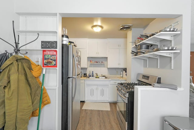 kitchen featuring sink, white cabinetry, appliances with stainless steel finishes, and light hardwood / wood-style flooring