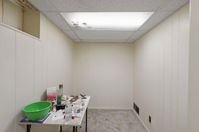 office featuring a paneled ceiling and light carpet