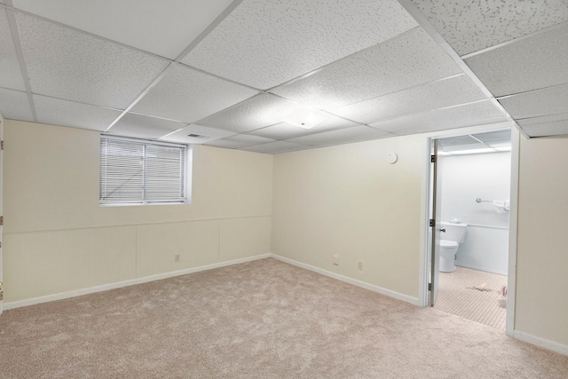 basement with light carpet and a paneled ceiling