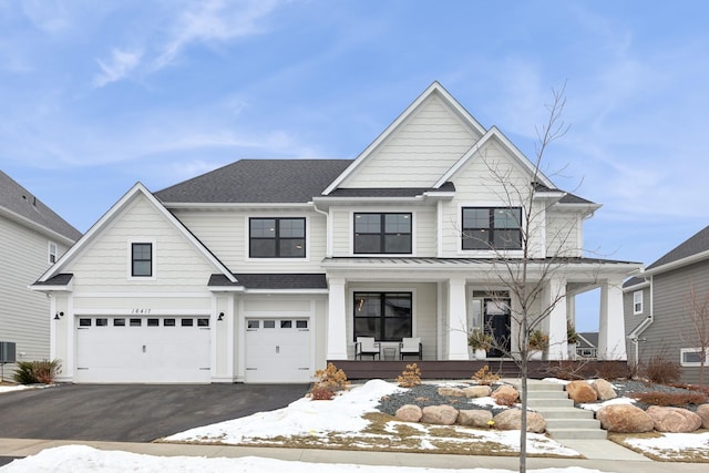 view of front of house with a garage, cooling unit, and covered porch