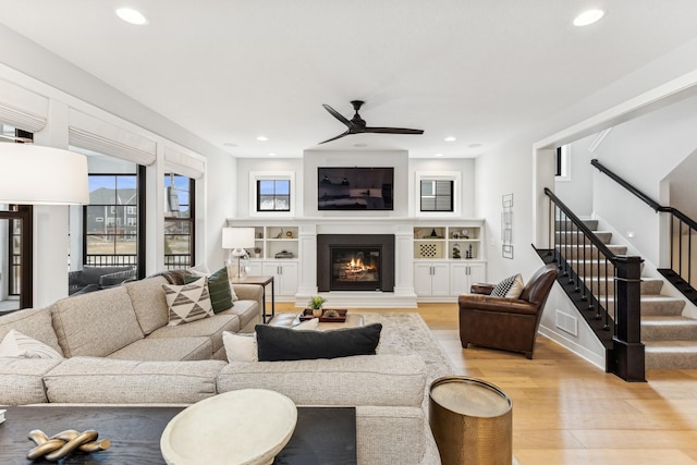 living room featuring ceiling fan and light hardwood / wood-style floors