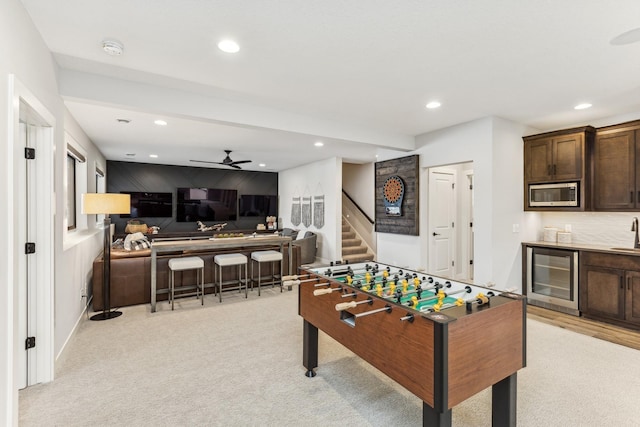 game room with wine cooler, light carpet, and indoor wet bar