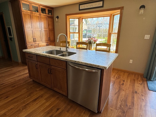 310 7th St SW, Roseau, MN 56751 - kitchen with brown cabinets, a sink, dark wood-style flooring, glass insert cabinets, and stainless steel dishwasher
