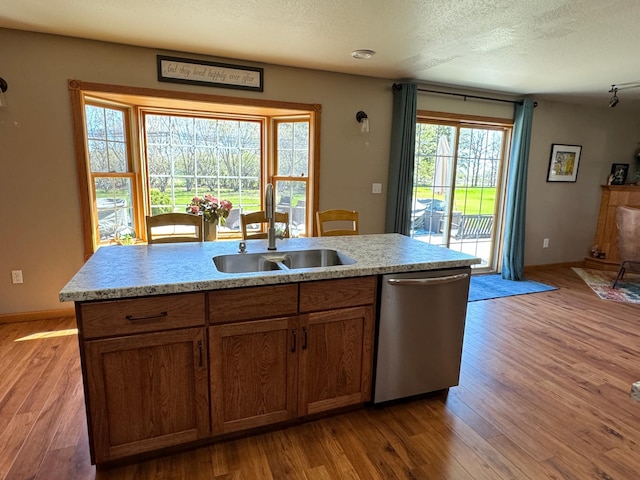 310 7th St SW, Roseau, MN 56751 - kitchen with wood finished floors, stainless steel dishwasher, light countertops, and a sink