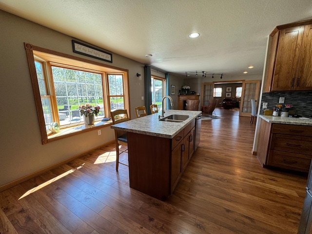 310 7th St SW, Roseau, MN 56751 - kitchen with stainless steel dishwasher, a sink, open floor plan, a textured ceiling, and dark wood-type flooring