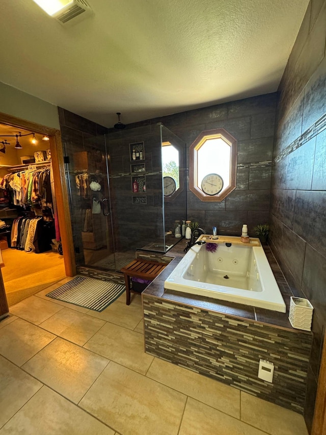 310 7th St SW, Roseau, MN 56751 - full bathroom featuring a shower stall, visible vents, a jetted tub, a spacious closet, and tile patterned flooring