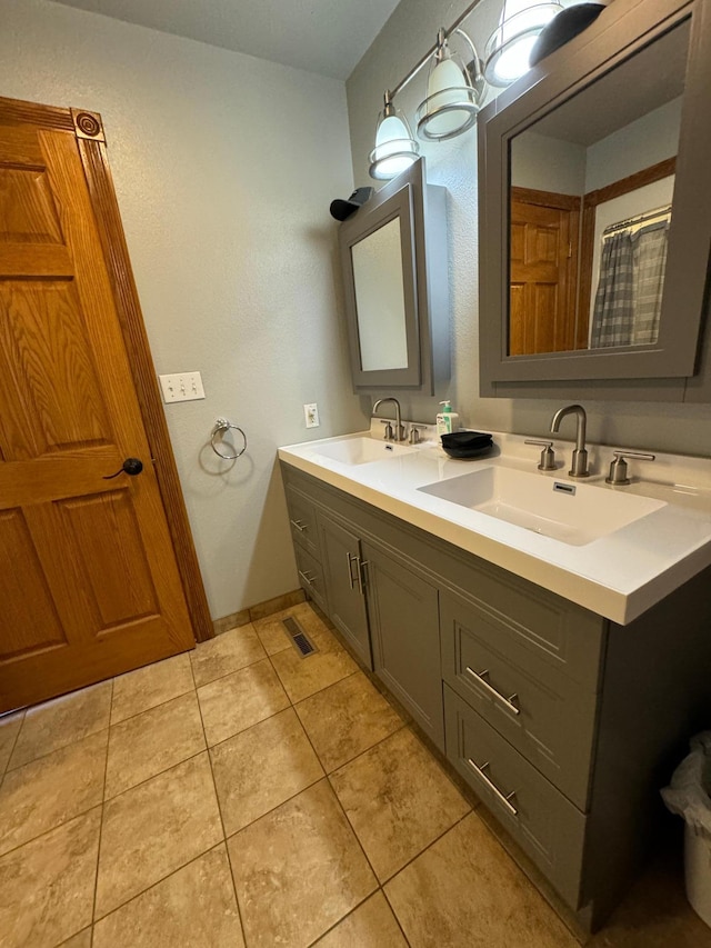 310 7th St SW, Roseau, MN 56751 - bathroom featuring tile patterned floors, visible vents, double vanity, and a sink