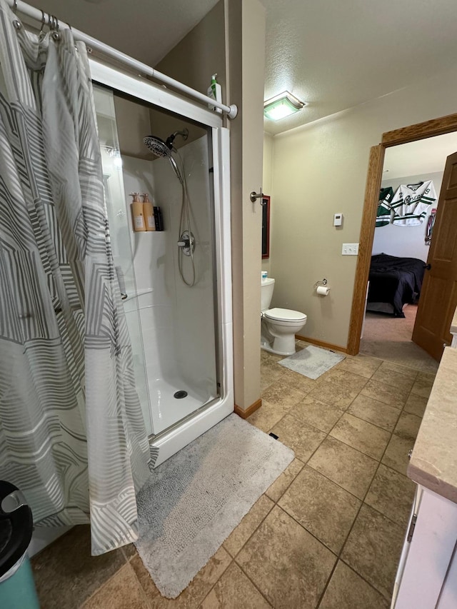 310 7th St SW, Roseau, MN 56751 - bathroom featuring a shower stall, vanity, toilet, baseboards, and ensuite bathroom