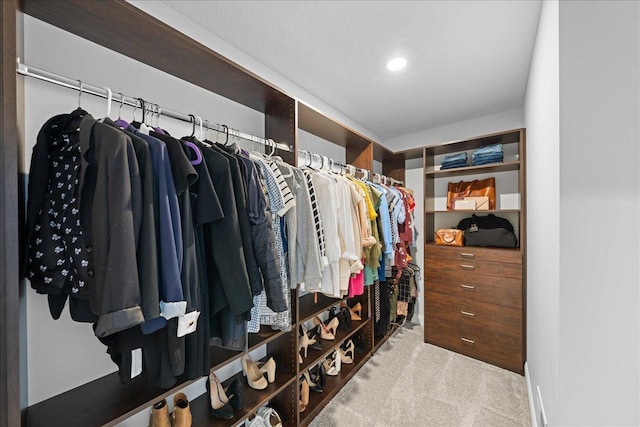 walk in closet featuring light carpet