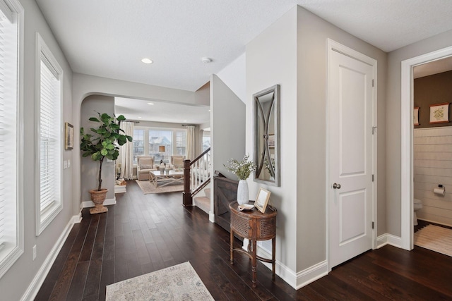 entryway with a textured ceiling, recessed lighting, dark wood-style flooring, baseboards, and stairway