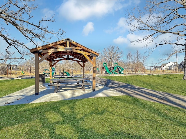 view of home's community featuring playground community and a yard