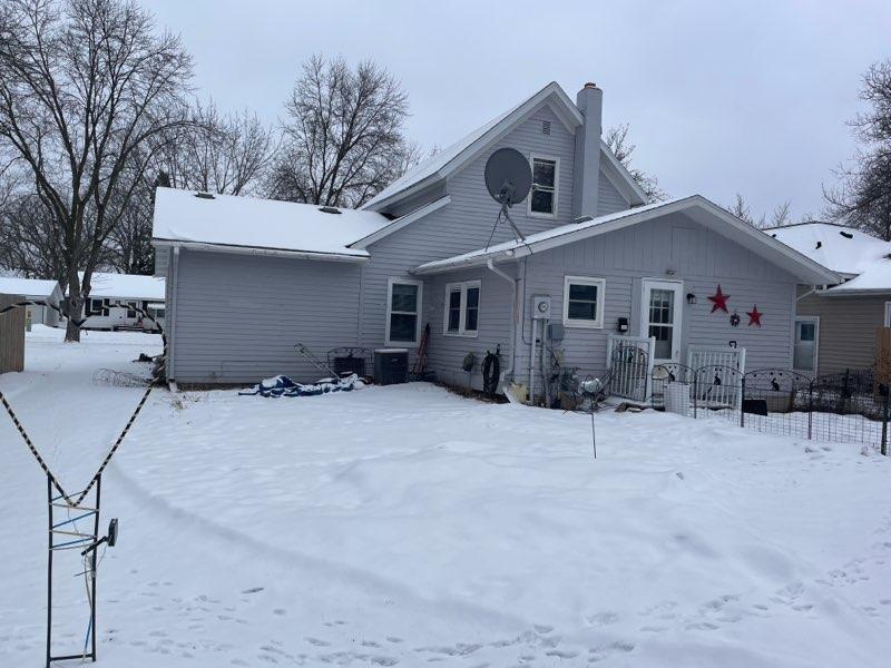 snow covered property with central AC