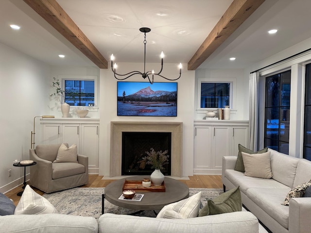 living room with beamed ceiling, an inviting chandelier, and light hardwood / wood-style floors