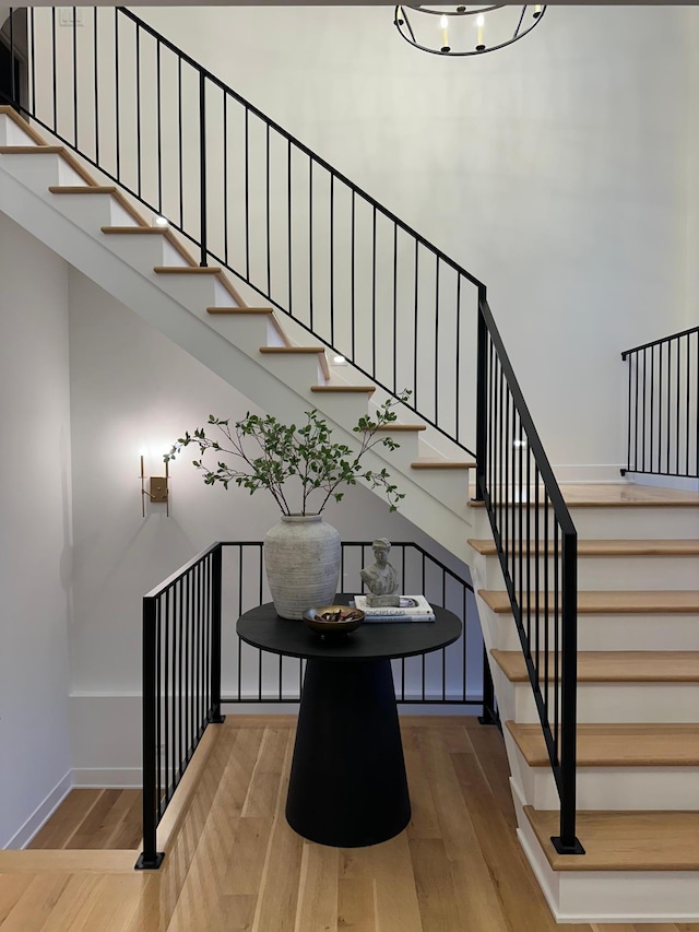 stairs with a high ceiling and hardwood / wood-style floors