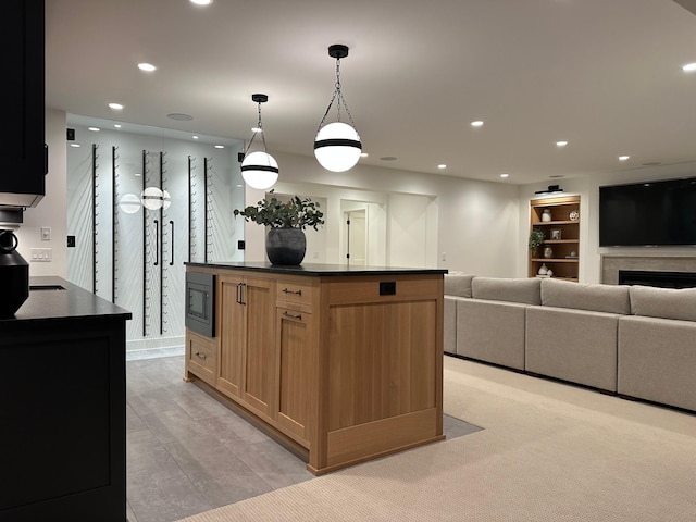 kitchen with a kitchen island, pendant lighting, and stainless steel microwave