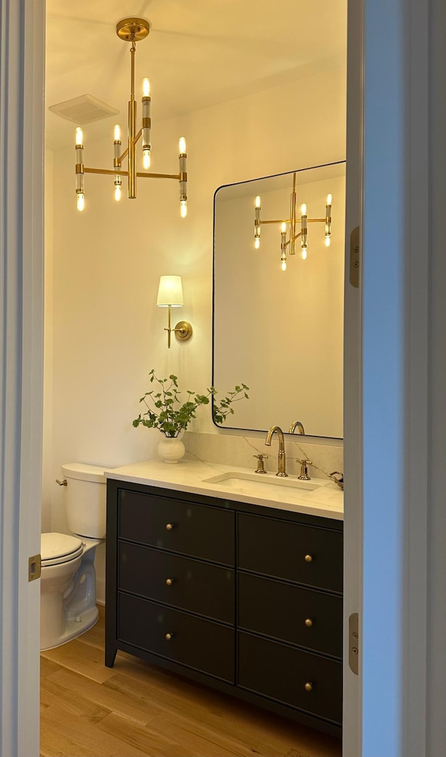 bathroom featuring vanity, toilet, and hardwood / wood-style floors