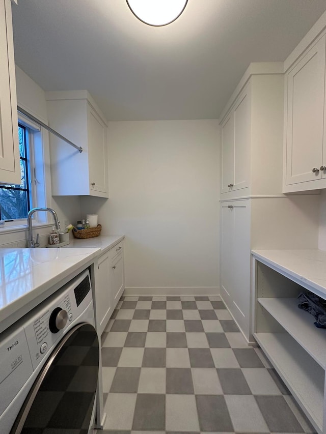 washroom featuring sink, washer / dryer, and cabinets