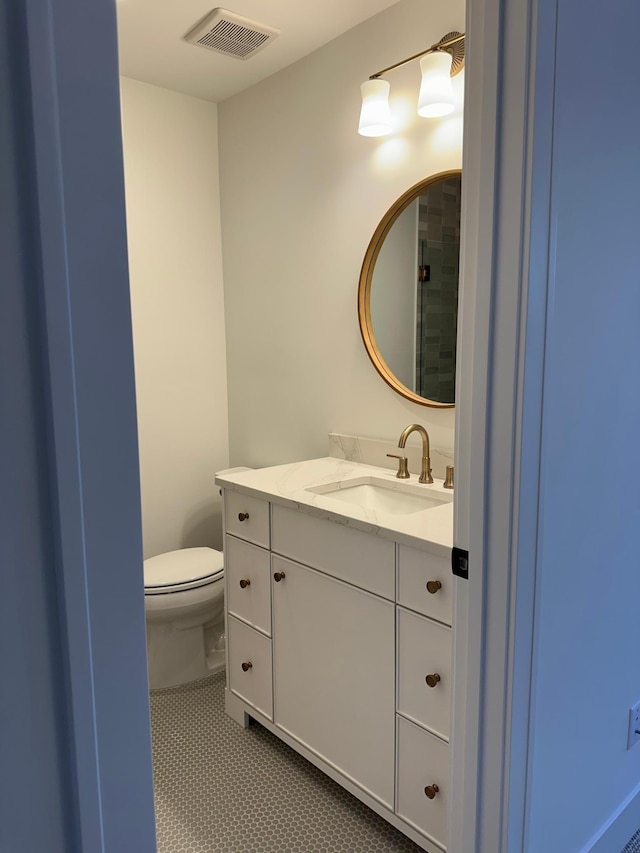 bathroom featuring vanity, tile patterned floors, and toilet