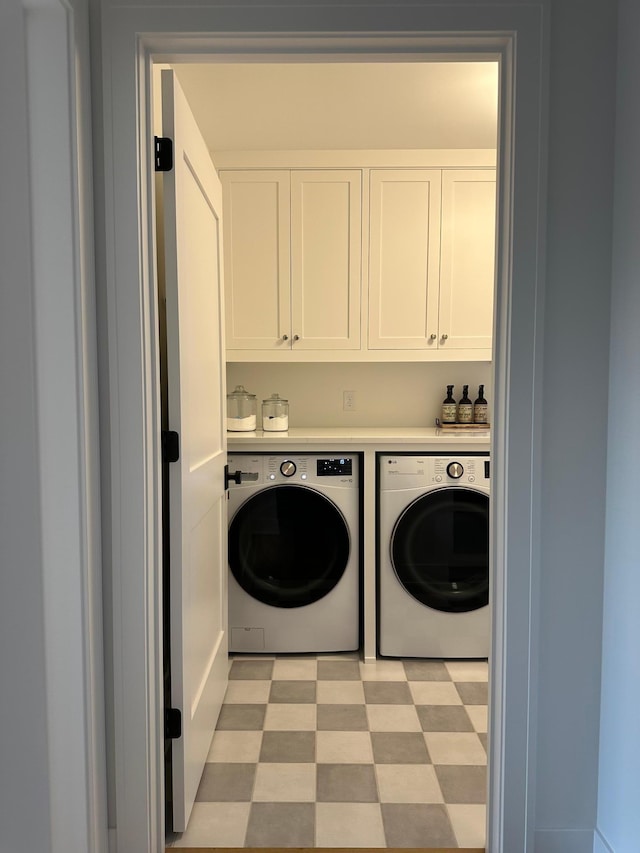 washroom with independent washer and dryer and cabinets