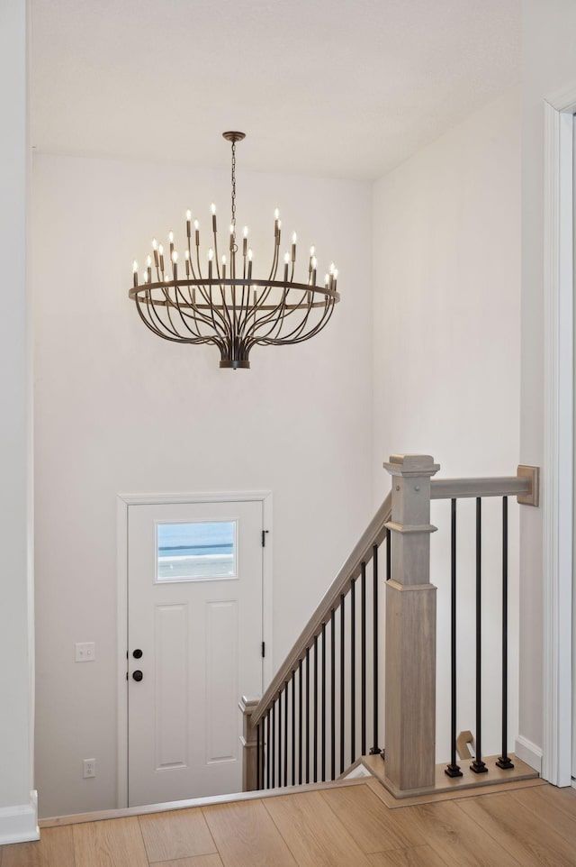 entrance foyer with hardwood / wood-style floors and a notable chandelier