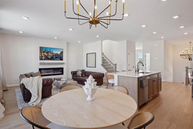 dining room featuring light hardwood / wood-style flooring, sink, and a notable chandelier