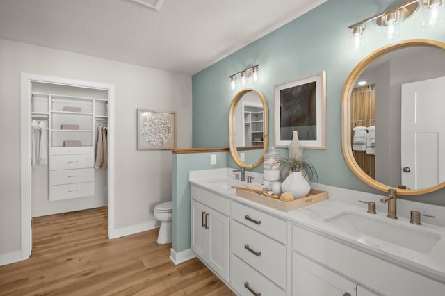 bathroom with toilet, hardwood / wood-style flooring, a textured ceiling, and vanity