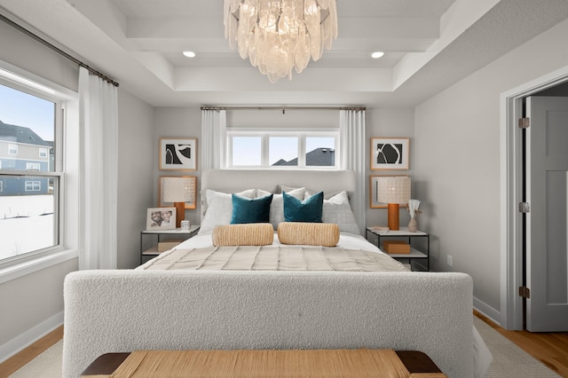 bedroom with wood-type flooring and an inviting chandelier