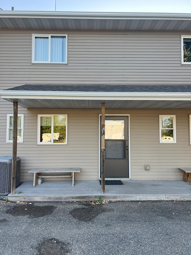 entrance to property featuring covered porch and central AC unit