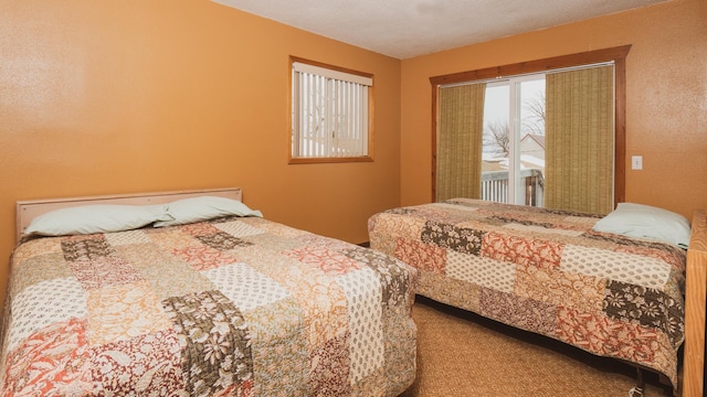 bedroom featuring access to exterior and a textured ceiling