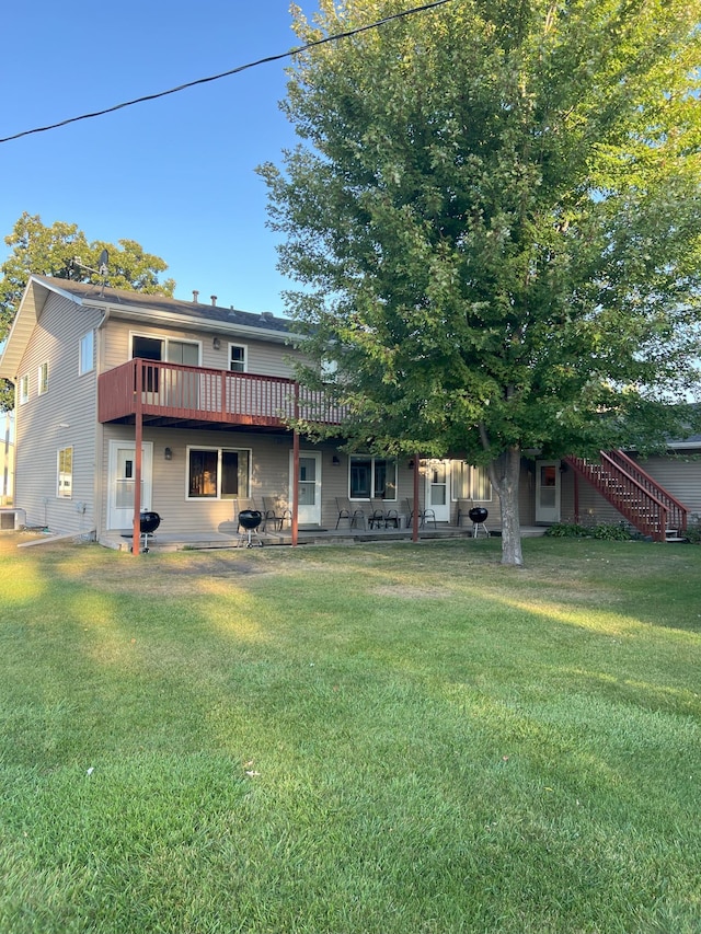 rear view of property with a deck and a yard