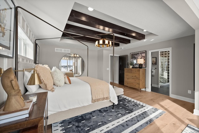 bedroom featuring beam ceiling, wood-type flooring, and a notable chandelier